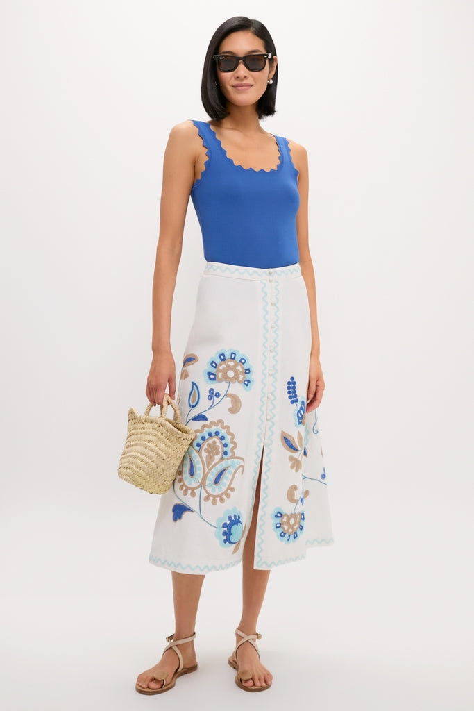 Model in a classic, high-end, embroidered Folk Flower Sadie Skirt with an effortless style, paired with a cobalt tank, tan sandals, and a fun straw tote.