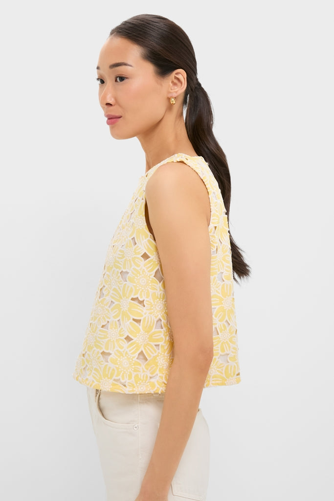 Woman in profile wearing the Pale Yellow Flower Vera Top, a classic sleeveless piece featuring daisy-patterned lace, paired with light-beige pants, exuding effortless, high-end style.