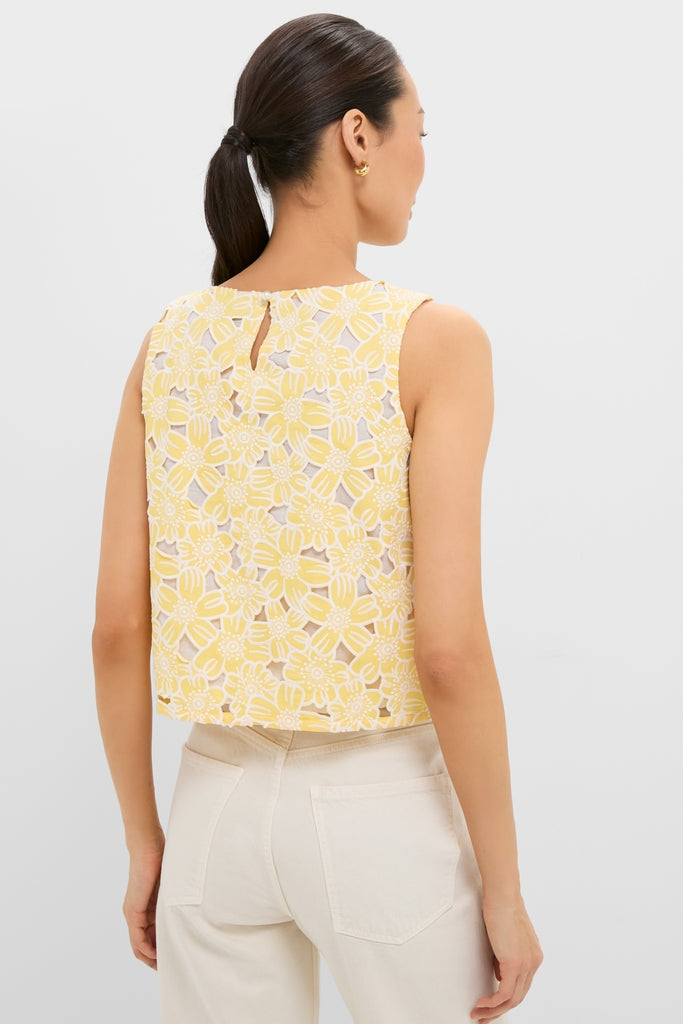 Woman wearing the Pale Yellow Flower Vera Top, showcasing its sleeveless, boxy-cut design with classic floral lace, paired with high-waisted, patch-pocket cream pants for an effortless, high-end look.