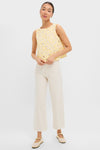 Young woman in a classic, effortless Pale Yellow Flower Vera Top, paired with high-waisted cream trousers and Mary-Jane flats, embodying Tuckernuck's fun and high-end style.