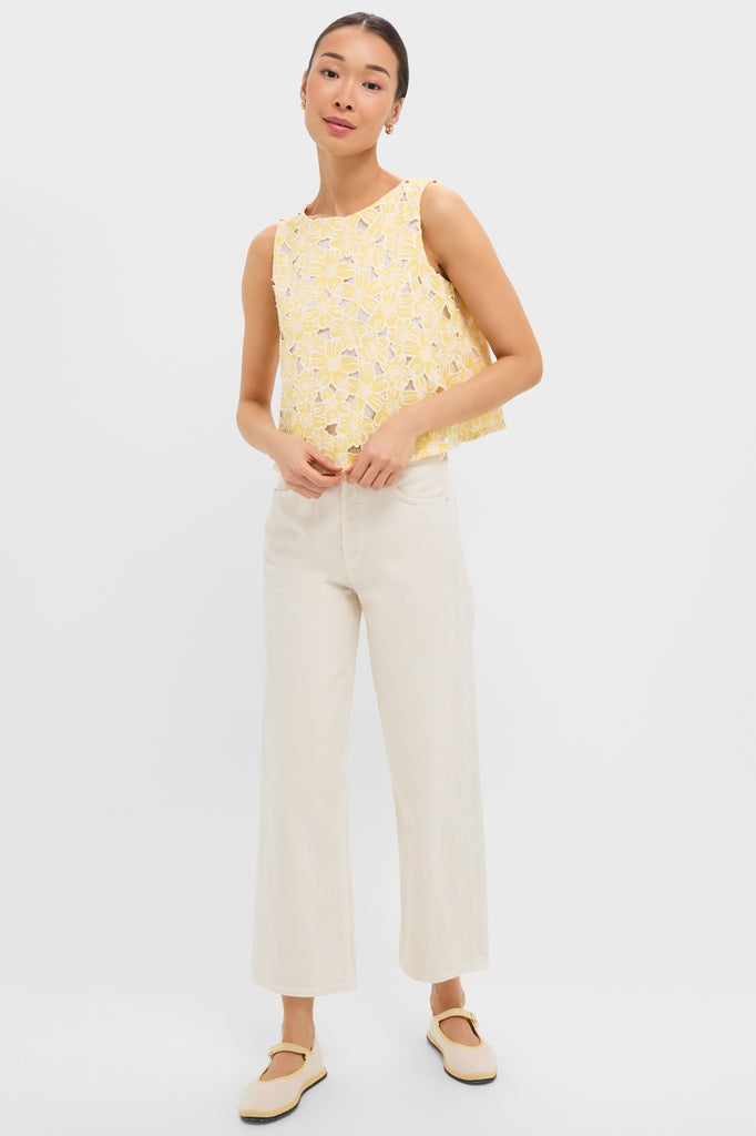 Young woman in a classic, effortless Pale Yellow Flower Vera Top, paired with high-waisted cream trousers and Mary-Jane flats, embodying Tuckernuck's fun and high-end style.