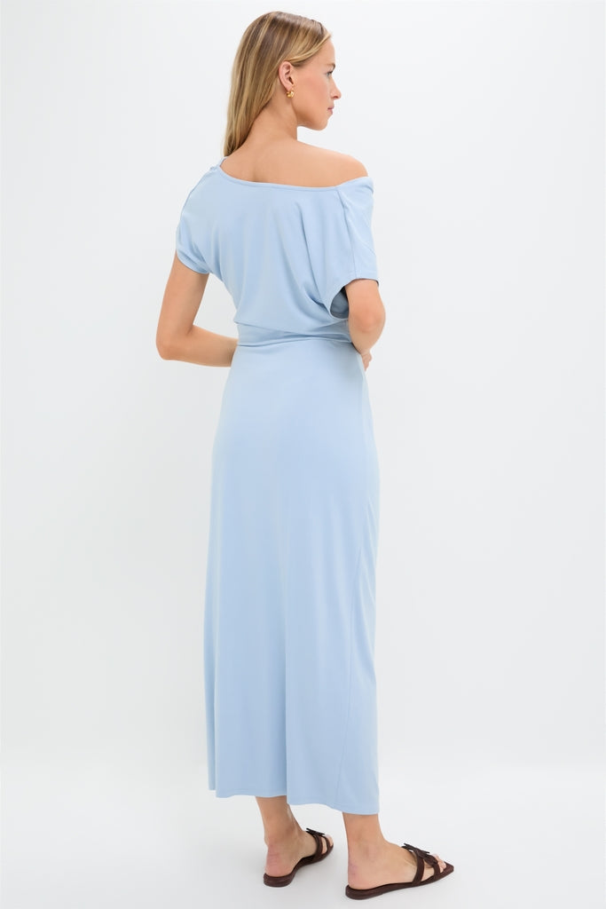 Woman in a Blue Fog Faux Wrap Senna Dress, showcasing an effortless, classic off-the-shoulder look with fun, high-end style.