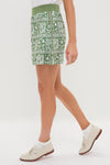 Classic and effortless Calypso Reef Performance Stretch Woven Karrie Golf Skirt paired with white ankle socks and cream leather loafers for a fun, high-end style.