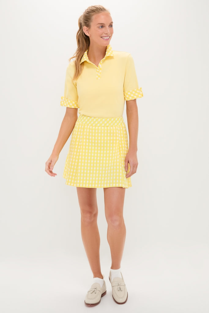 Woman wearing the Lemon Yellow Prynn Polo with gingham collar and matching pleated skirt, embodying a classic, effortless, and fun style with high-end appeal.