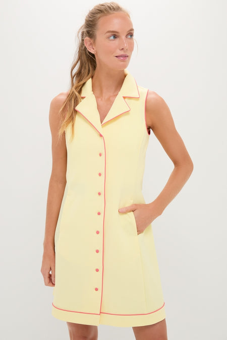 Woman models the classic, high-end Lemon Yellow Georgia Golf Dress, featuring effortless style with contrast piping and fun side-seam pockets, embodying Tuckernuck’s cool, confident aesthetic.