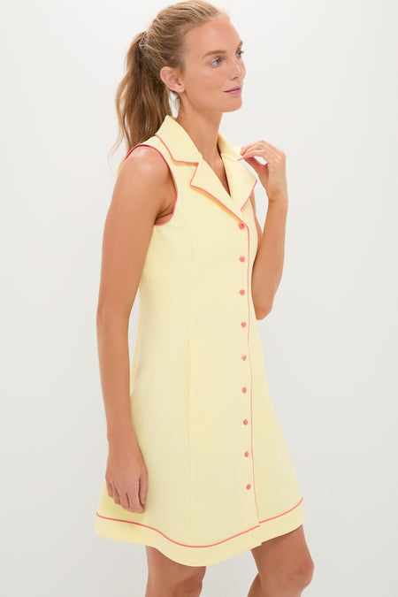 Model wearing the Lemon Yellow Georgia Golf Dress, a classic and effortless sleeveless design with pink piping, notched collar, and button-front, embodying high-end, fun style.