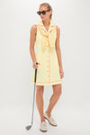 Model wearing the classic Lemon Yellow Georgia Golf Dress with matching sweater, white loafers, and sunglasses, holding a golf club for an effortless, high-end look.