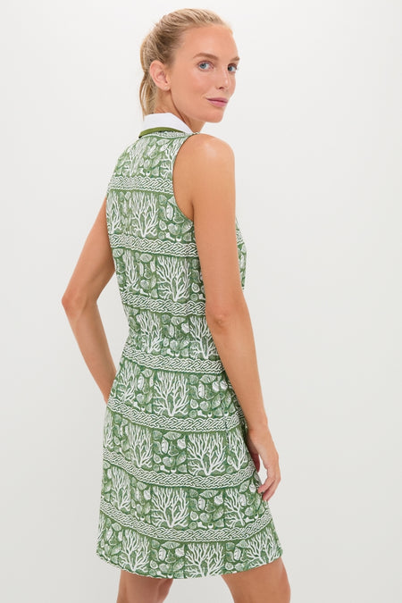 Woman models the Calypso Reef Sleeveless Performance Jersey Alcott Golf Dress, showcasing its classic, effortless style with sea-life motifs, perfect for fun, high-end wear.