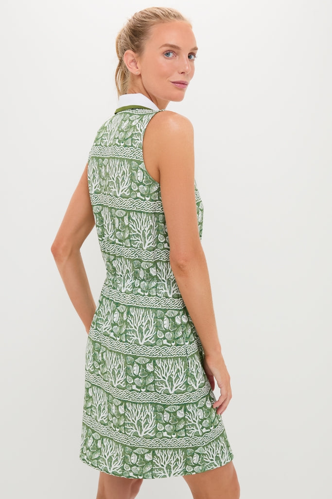 Woman models the Calypso Reef Sleeveless Performance Jersey Alcott Golf Dress, showcasing its classic, effortless style with sea-life motifs, perfect for fun, high-end wear.