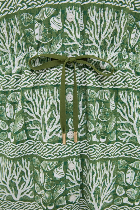 Calypso Reef Sleeveless Performance Jersey Alcott Golf Dress with a chic coral-and-shell print, button front, and drawstring waist, offering an effortless, high-end look for active days.