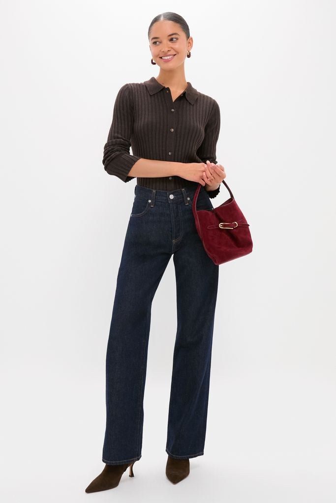 Woman wearing a classic Chocolate Fine Rib Knit Button Down Myers Polo with high-rise jeans and suede boots, accessorized with a burgundy handbag, exuding an effortless, high-end style.