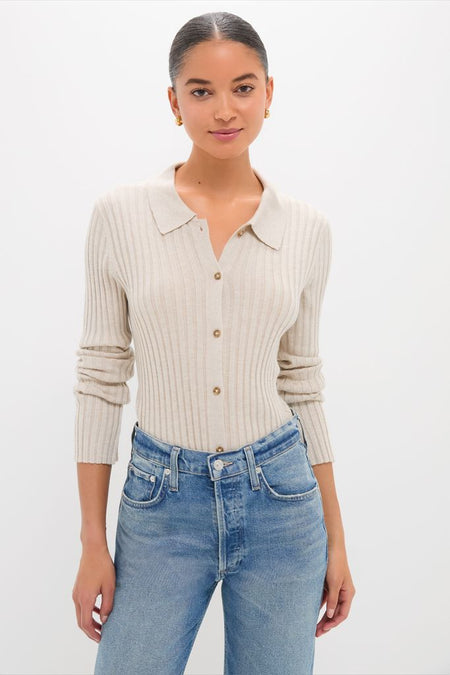 Young woman wearing the Sandstone Fine Rib Knit Button Down Myers Polo, a classic and effortless light-beige cardigan, paired with high-waisted jeans, embodying a high-end and fun style.