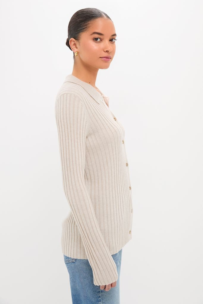 Young woman models the classic and effortless Sandstone Fine Rib Knit Button Down Myers Polo, paired with denim jeans, embodying a high-end, fun style.