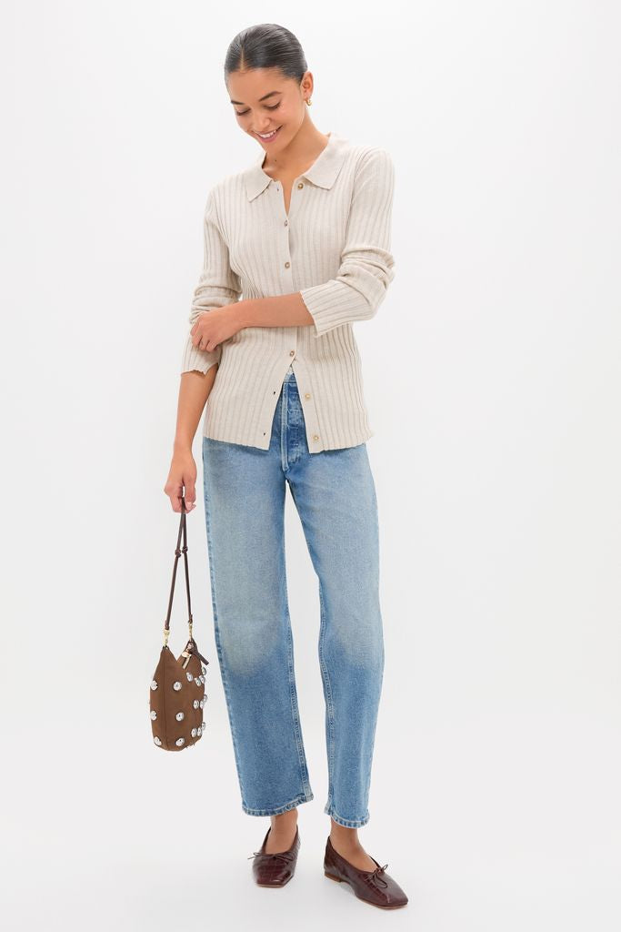 Woman wearing classic Sandstone Fine Rib Knit Button Down Myers Polo with a polo collar, paired with high-waisted jeans and loafers, holding a chic floral bucket handbag.