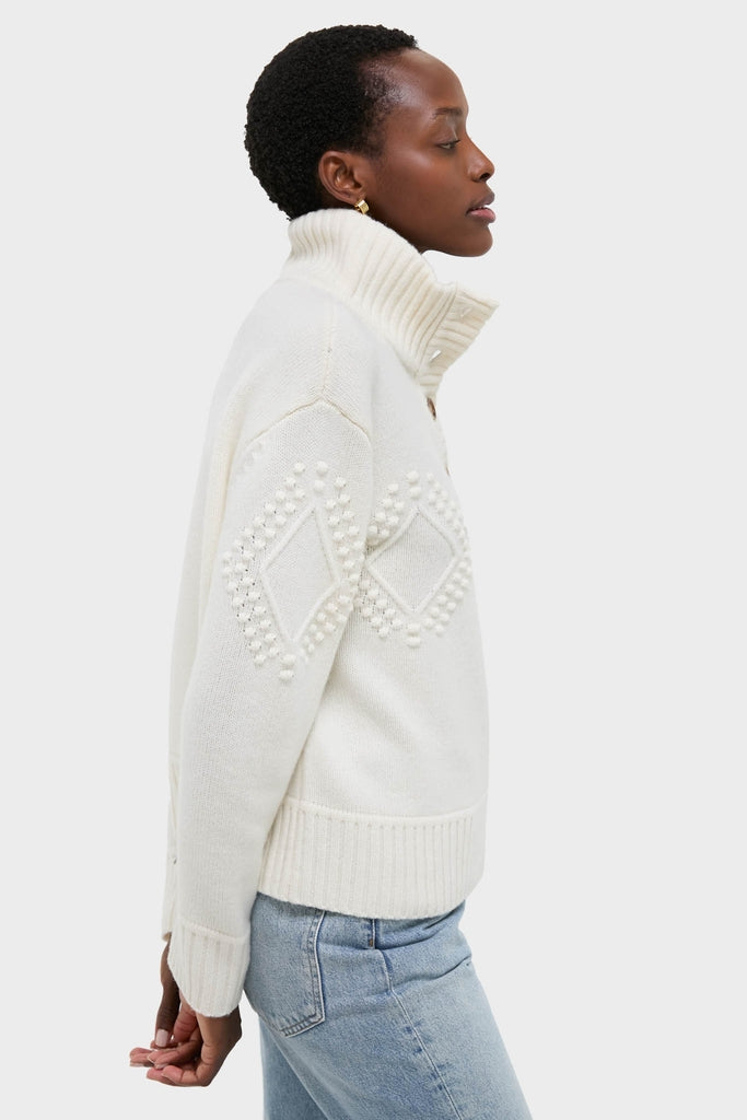 Ivory Henry Button-Up Sweater in chunky knit features a high turtleneck and bobble-stitch sleeves, paired with jeans for a classic, effortless, and high-end winter look.