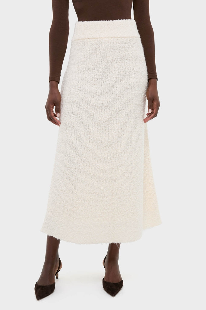 Ivory Boucle Lillia Sweater Skirt offers an effortless, classic A-line silhouette with a high-waisted, textured design, paired perfectly with a slim-fit top for a high-end look.