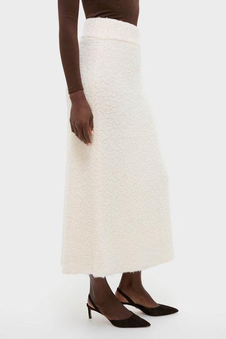 Ivory Boucle Lillia Sweater Skirt exudes classic, high-end elegance with its textured A-line silhouette, styled effortlessly with chic sling-back pumps for fun winter gatherings.