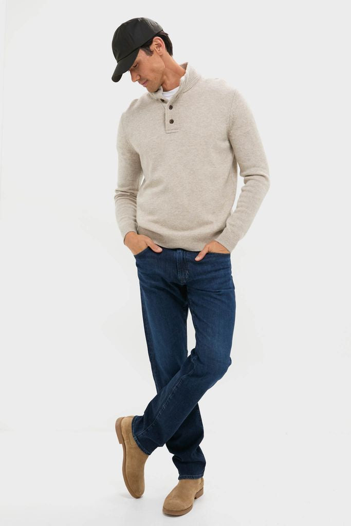 Man models the Oat Cashmere Wool Button-Up, a classic, high-end pullover with a button placket, perfect for an effortless, fun winter style.