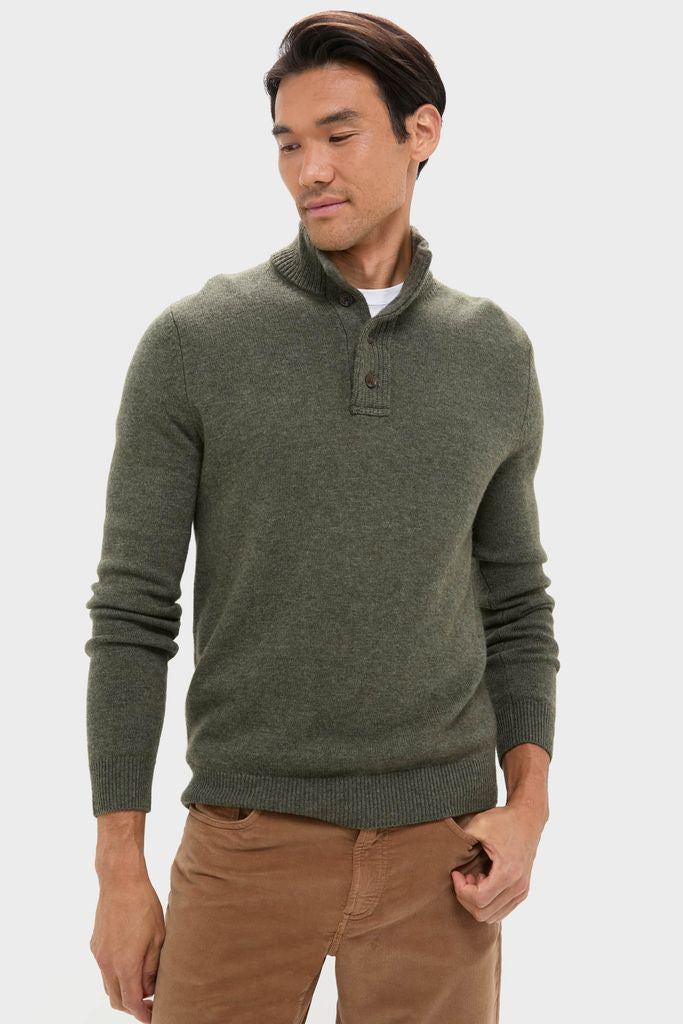 Man in Olive Green Cashmere Wool Button-Up sweater with three-button placket, paired effortlessly with tan pants, embodies a classic, high-end style. Perfect for fun, cool-weather occasions.