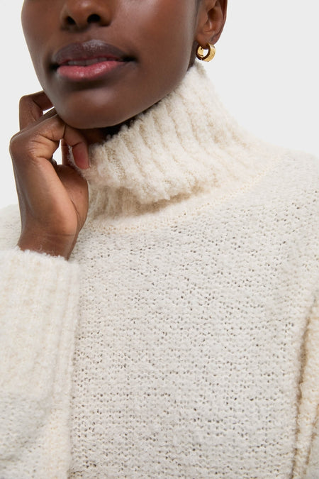 Person wearing the Ivory Boucle Whilden Sweater Top, a classic, high-end ribbed turtleneck, effortlessly chic with a relaxed fit, showcasing the boucle texture and fun, cozy elegance.