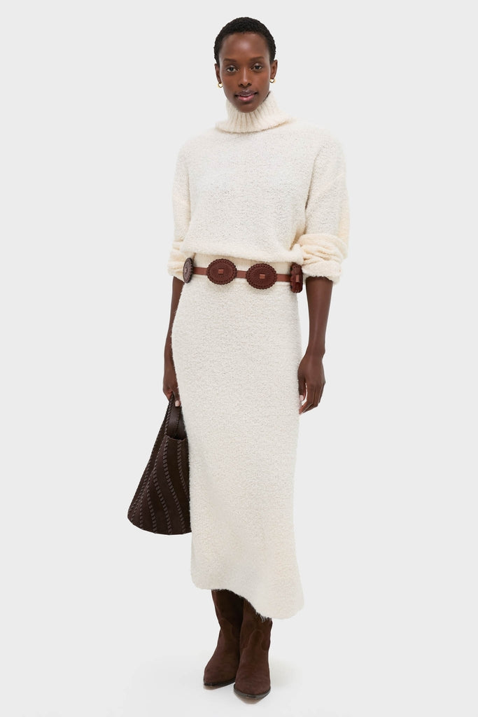 Model showcases the Ivory Boucle Whilden Sweater Top, a classic, effortless knit with a relaxed turtleneck and ribbed finishes, paired with a matching skirt for a high-end, fun winter look.