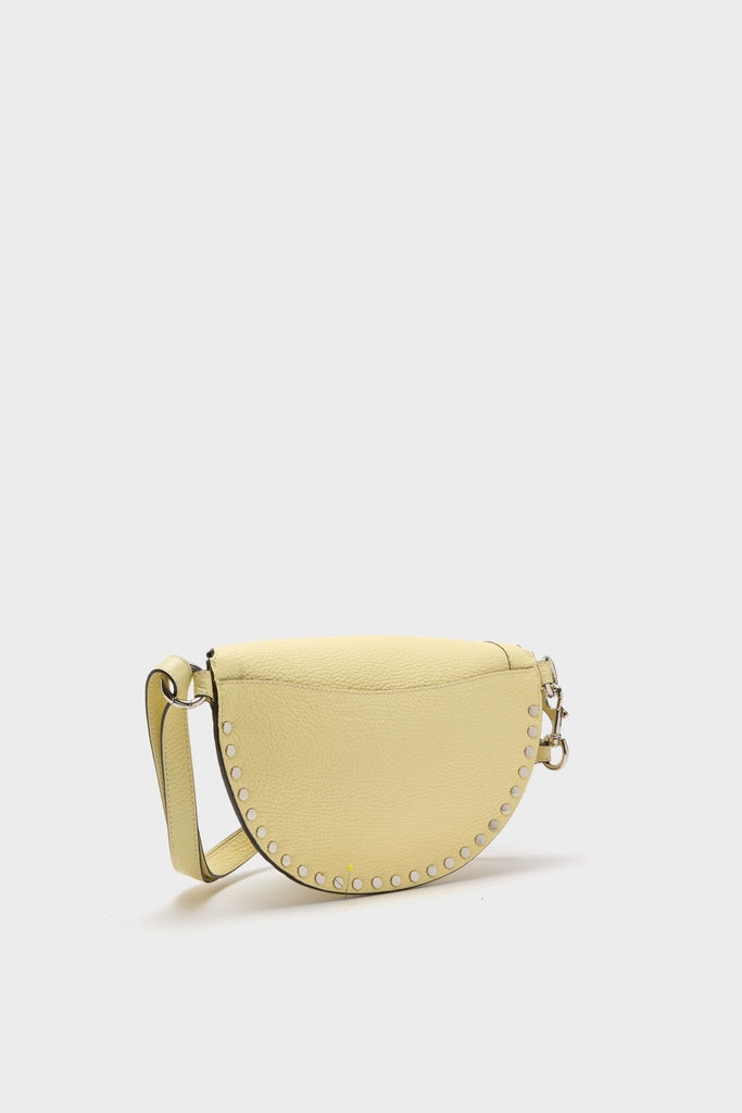 Butter Skano Fannypack: A classic, half-moon crossbody bag in pebbled yellow leather, featuring silver-tone studs and an adjustable strap for an effortless, high-end look.