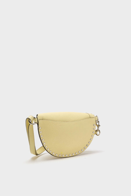 Butter Skano Fannypack: A classic, half-moon crossbody bag in pebbled yellow leather, featuring silver-tone studs and an adjustable strap for an effortless, high-end look.