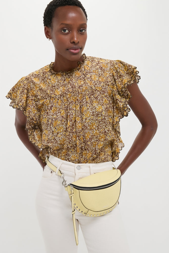 Model wearing a classic, effortless ensemble featuring the Butter Skano Fannypack, a high-end, fun leather belt bag with black zipper and metal stud details.