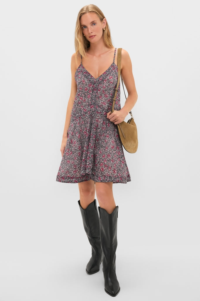 Woman models classic, sleeveless floral mini dress with cowboy boots and Taupe Oskan Soft Zip Shoulder Strap, embodying effortless, high-end style.