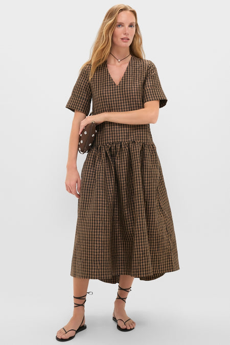 Model wearing Tobacco Brown Crinkled Taffeta Check Long Dress with V-neck and short sleeves, styled with black lace-up sandals and a brown clutch for an effortless, high-end look.