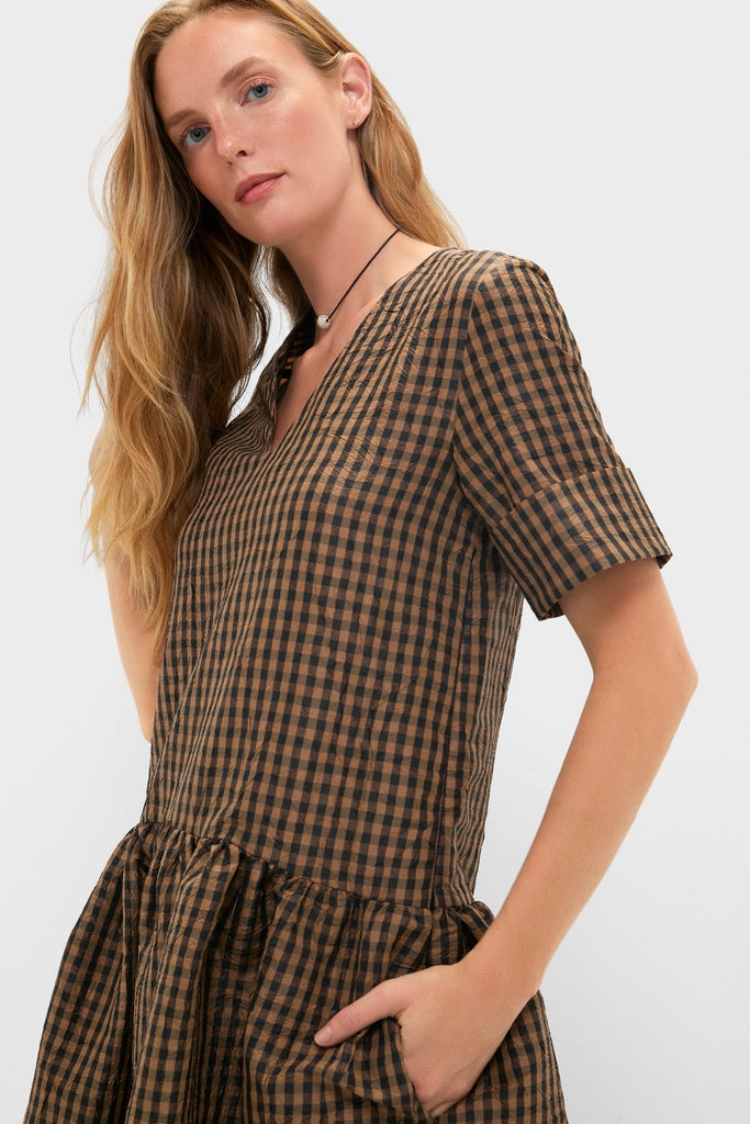 Woman wearing the classic Tobacco Brown Crinkled Taffeta Check Long Dress with V-neckline, drop waist, and side pocket. Effortless style with elbow-length sleeves and necklace.