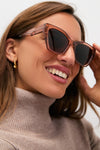 Woman wearing Cafe Ole Evie Polarized Sunglasses; classic, oversized, translucent-brown frame with polarized lenses. Effortlessly cool and fun for everyday adventures.