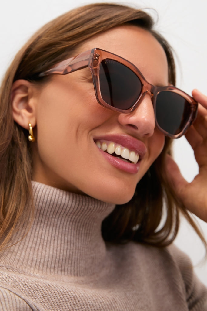 Woman wearing Cafe Ole Evie Polarized Sunglasses; classic, oversized, translucent-brown frame with polarized lenses. Effortlessly cool and fun for everyday adventures.