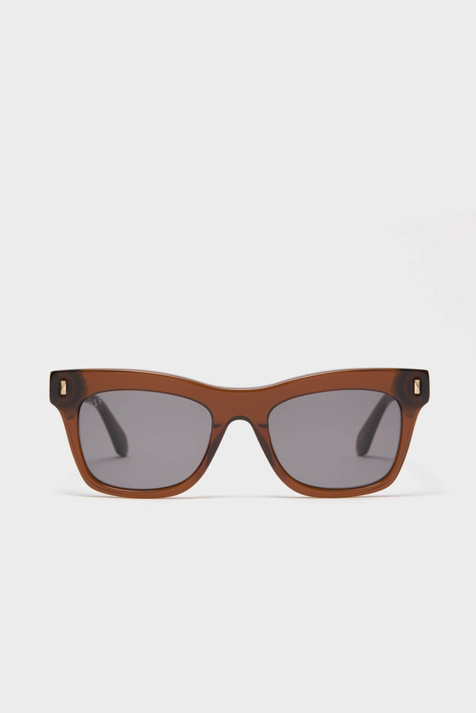 Whiskey Bradley Sunglasses with translucent brown frames and dark lenses offer a classic, effortless, high-end look, embodying fun and confidence with chunky acetate and gold details.