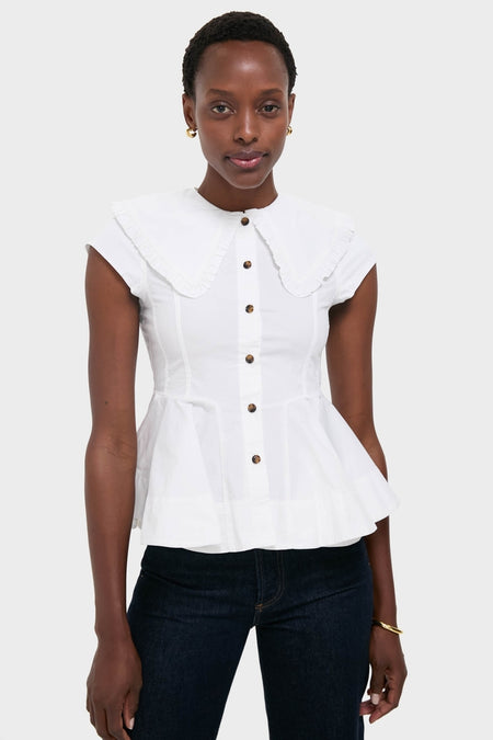 Person wearing the Bright White Stretch Cotton Peter Pan Collar Shirt with a ruffled collar and front buttons, paired effortlessly with dark denim jeans, exuding a classic, high-end style.