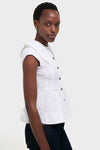 Woman models a classic, high-end Bright White Stretch Cotton Peter Pan Collar Shirt with a peplum hem, paired effortlessly with dark jeans and gold hoop earrings.