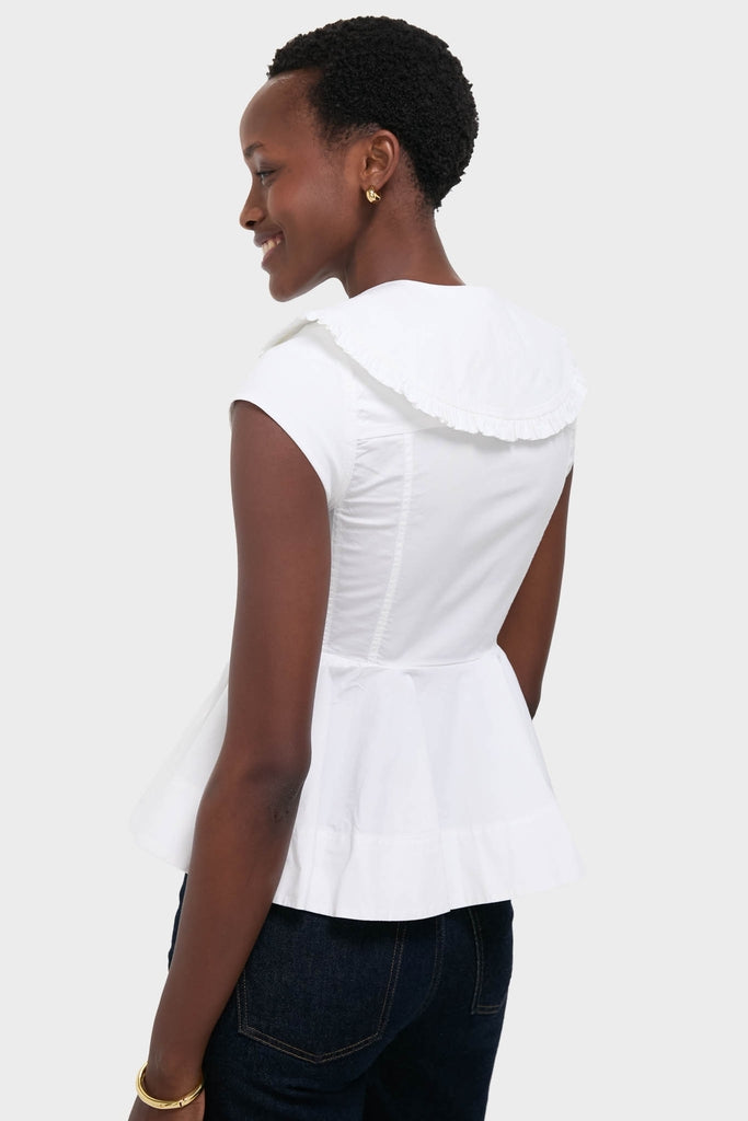 Woman wearing the Bright White Stretch Cotton Peter Pan Collar Shirt with ruffled collar, styled effortlessly with dark jeans, exuding a classic and high-end look.