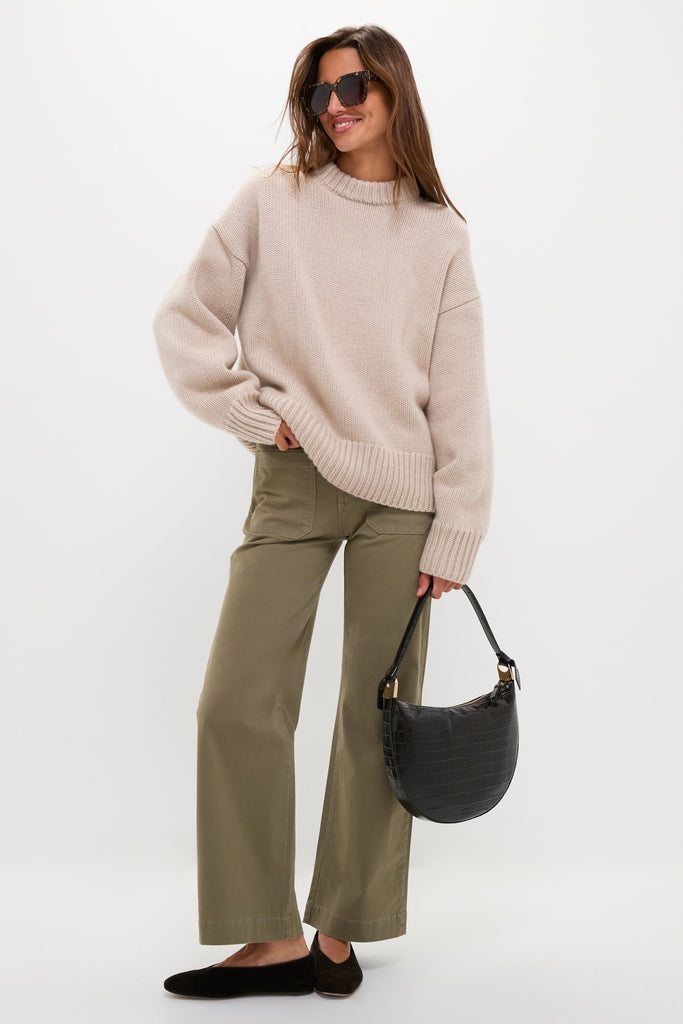Woman in oversized knit sweater and wide-leg trousers, wearing classic Glitter Tortoise Ariana Polarized Sunglasses, exuding effortless high-end style with fun, chic flair.