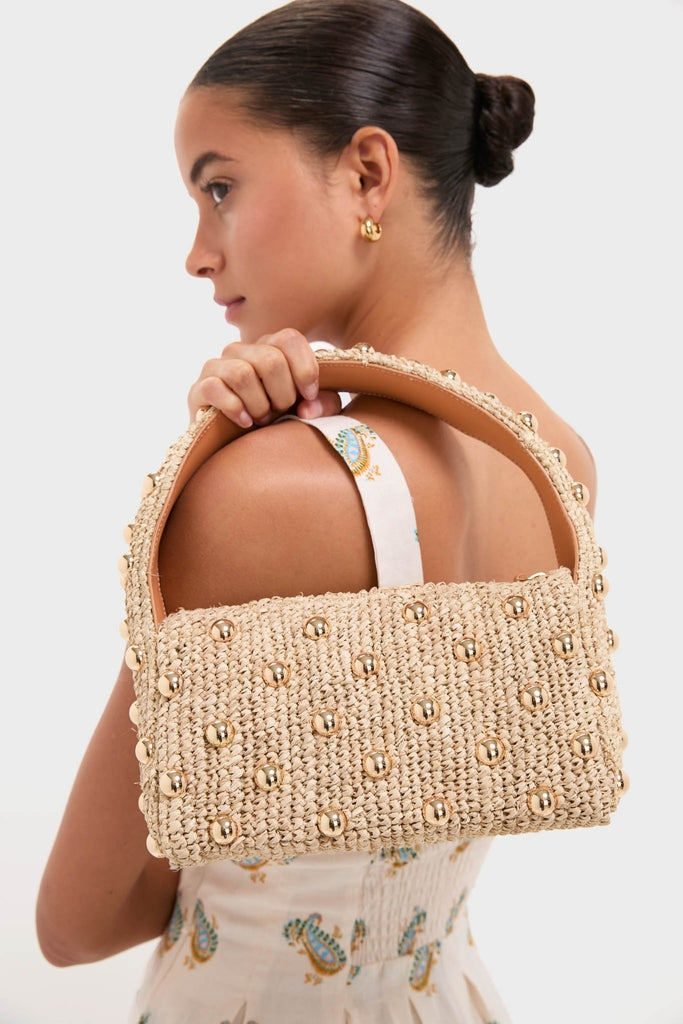 Young woman in a light sundress carries a classic woven straw bag, pairing effortlessly with a high-end Pearl Necklace with Carpe Diem Charm, embodying fun and stylish elegance.