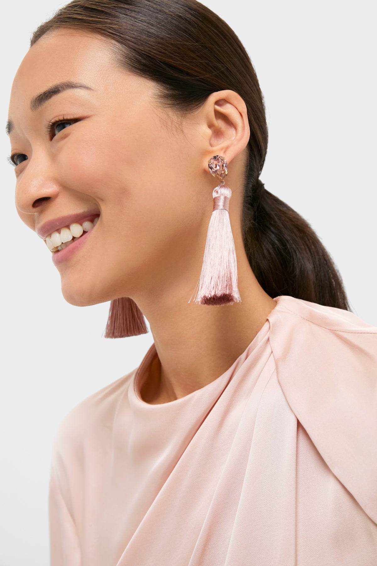 Woman wearing Vintage Rose Francine Earrings: classic, high-end tassel earrings with pear-cut crystals, embodying effortless glam and fun sophistication. Ideal for making a statement at elegant events.