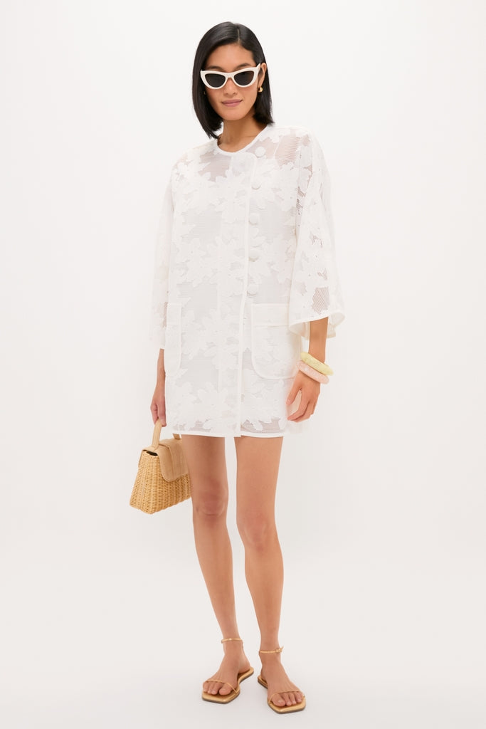 White Floral Lace Sidney Coverup: A classic, effortless mini-dress featuring sheer lace, patch pockets, and elbow-length sleeves, styled with chic accessories for a fun, high-end look.