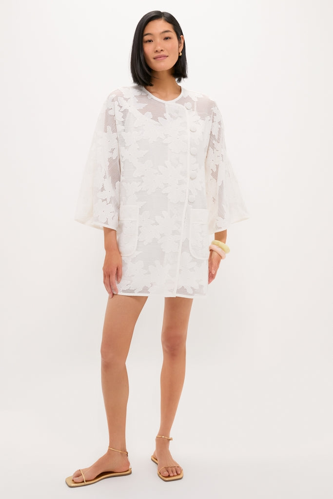White Floral Lace Sidney Coverup: A classic, high-end, semi-sheer jacket with floral lace-mesh, bell sleeves, and fabric-covered buttons, exuding effortless and fun elegance.