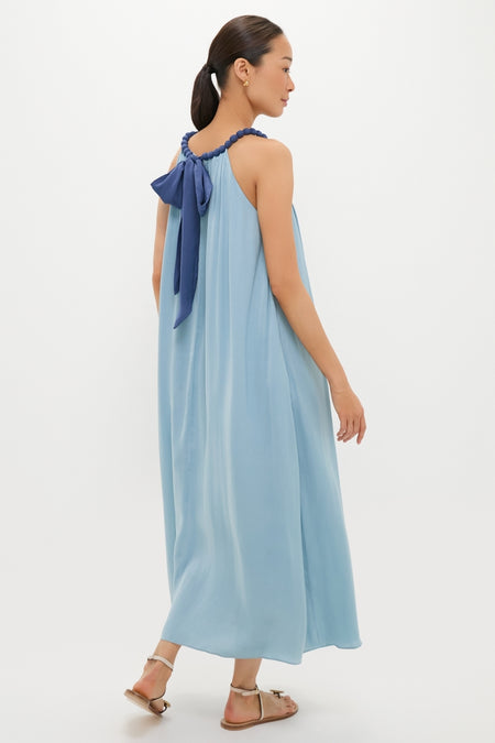 Woman in a classic, ankle-length Light Blue Chiffon Amelia Bauble Dress with a navy bow, embodying effortless elegance and fun style, perfect for any high-end occasion.