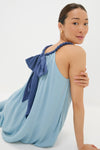 Young woman models the classic Light Blue Chiffon Amelia Bauble Dress, featuring an effortless drape and fun beaded halter neckline, embodying Tuckernuck's high-end, confident style.