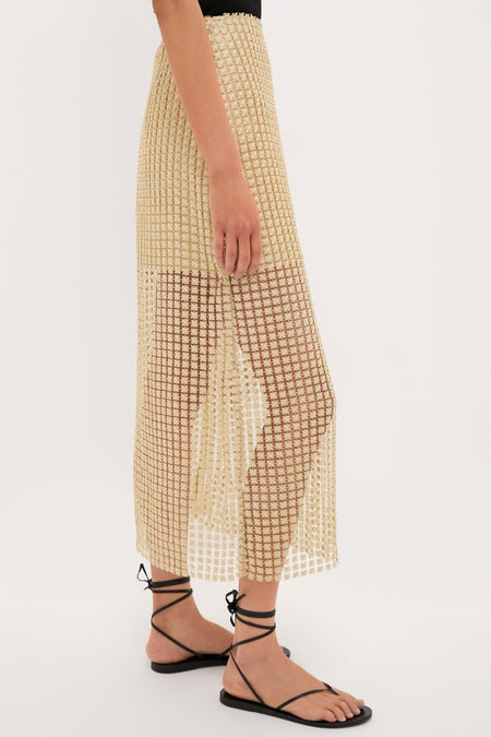 Woman wearing the Gold Metallic Star Lace Eve Skirt, featuring a classic, effortless style with a side slit, paired with fun, high-end black strappy sandals.