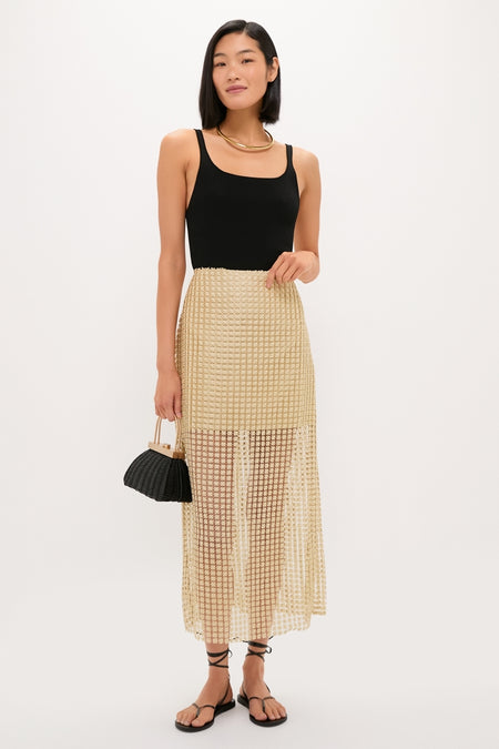 Young woman models the high-end Gold Metallic Star Lace Eve Skirt, exuding effortless glam with its airy texture and classic style, epitomizing Tuckernuck's fun, confident fashion.