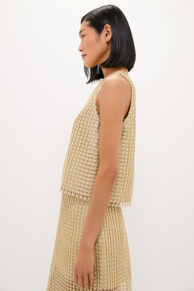 Young woman in profile wearing a classic, high-end Gold Metallic Star Lace Keating Top, exuding effortless style with its textured shimmer, perfect for fun and chic occasions.