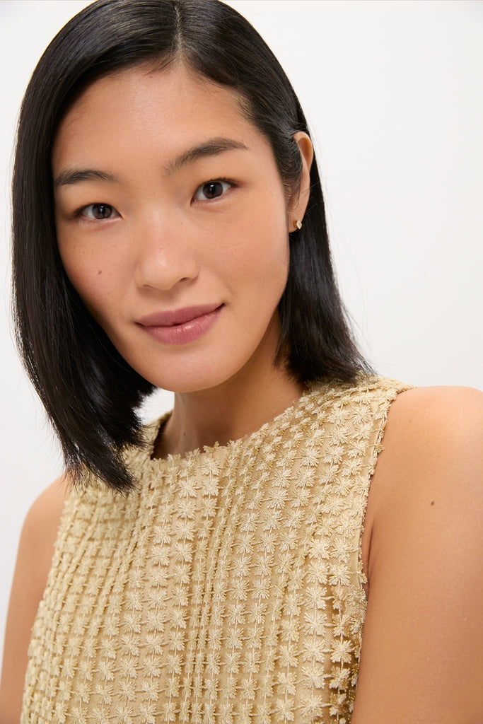 Young woman models the Gold Metallic Star Lace Keating Top, a classic, effortless sleeveless piece with shimmering star motifs, perfect for high-end, fun occasions.