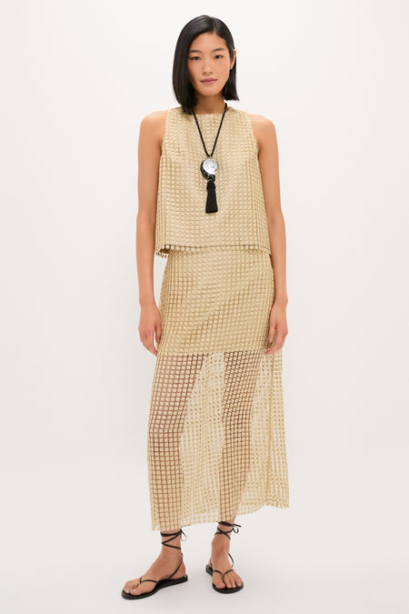 Young woman in a classic, effortless gold Metallic Star Lace Keating Top and Eve Skirt, exuding fun, high-end style with a chic, coordinated look.