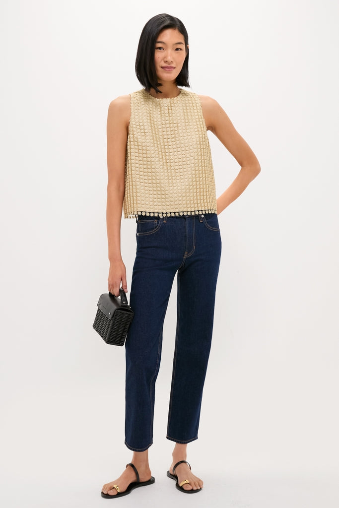Woman wearing a classic, high-end gold metallic star lace Keating top, paired with dark jeans and black sandals, exuding an effortless and fun style.